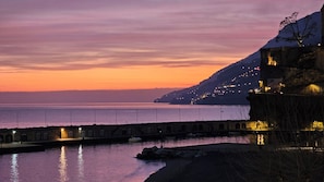 A coastal scene with a bridge, calm water, and a hillside with lights. - Galene - Beachfront in Costa d'Amalfi (Maiori)