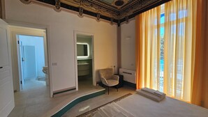 A spacious room with a large window, a chair, and a sink. - Galene - Beachfront in Costa d'Amalfi (Maiori)