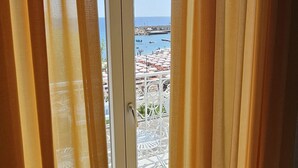 A view from a balcony with curtains, overlooking a beach with umbrellas and a pier. - Galene - Beachfront in Costa d'Amalfi (Maiori)