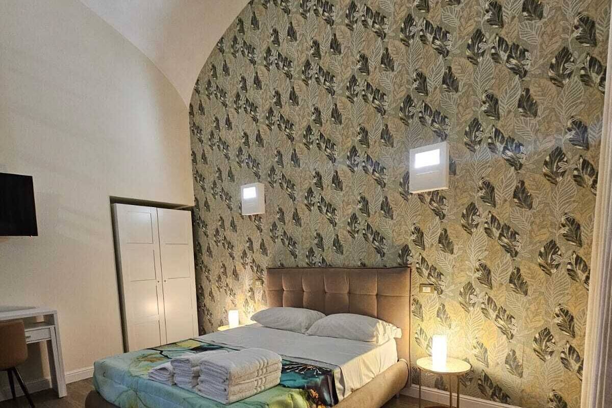 A bedroom with a bed, a desk, and a chair.