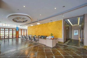 A spacious lobby with a reception desk, seating area, and a large window. - Xinxing Garden Hotel (Sanyawan) (Sanya)