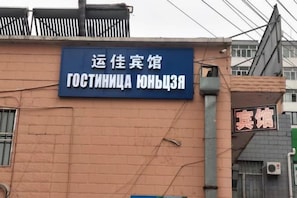 Um edifício com uma placa que diz 'Gostinitsa Iounitsa' em escrita cirílica.