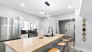 Una cocina moderna con una isla central, electrodomésticos de acero inoxidable y un diseño minimalista.