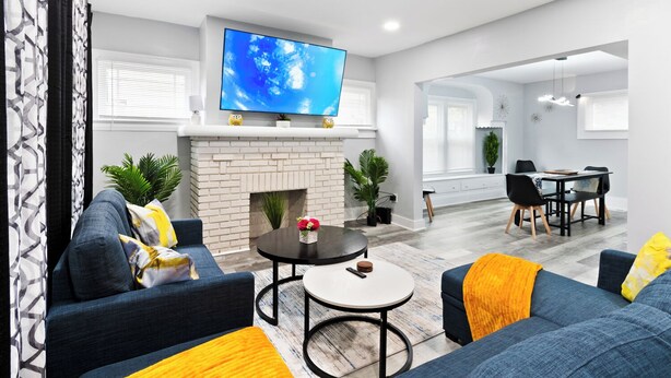 Una sala de estar moderna con chimenea, un televisor de pantalla plana y un comedor.