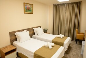 Standaard Twin kamer | Een minibar, een bureau, een laptopwerkplek, een strijkplank/strijkijzer