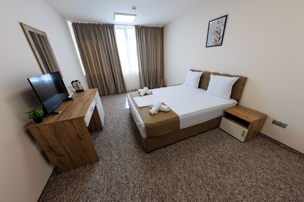 Standaard tweepersoonskamer | Een minibar, een bureau, een laptopwerkplek, een strijkplank/strijkijzer