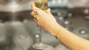 A hand holding a champagne glass with a strawberry garnish. - Suite soledad (Maraussan)