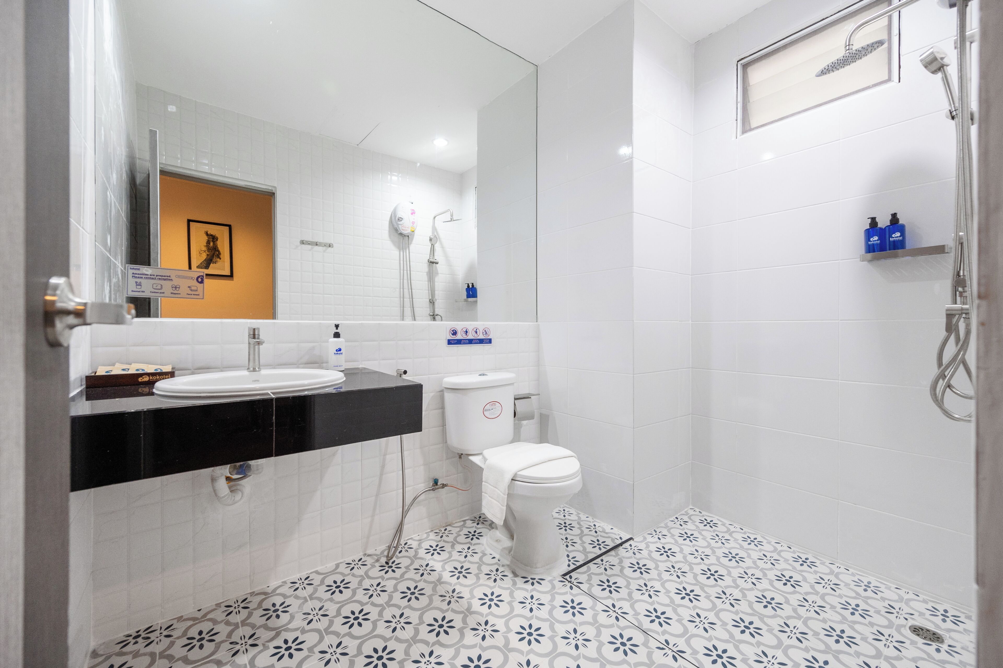 A modern bathroom with a white sink, toilet, and shower.