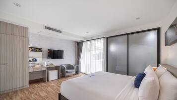 Et moderne hotelværelse med seng, skrivebord, stol og fjernsyn.