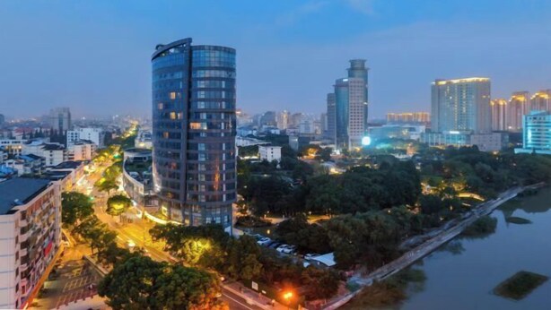 A cityscape with modern high-rise buildings, a river, and a bridge. - Metropolo Jinjiang Hotel(Kunshan Jinying international Kunju theater store) (Kunshan)
