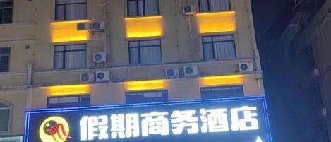 Señal de hotel con un número de teléfono y una flecha que apunta a la derecha.