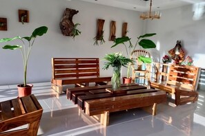 Un interior moderno con muebles de madera, plantas en macetas y adornos en las paredes.