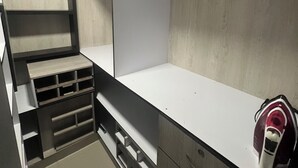 A compact, modern closet with built-in shelves and drawers, a hanging rod, and a mirror. - Casa Villa Carolina 5 min Puerta de Oro (Barranquilla)