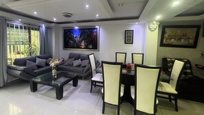 A modern living room with a sofa, coffee table, dining table, and chairs. - Casa Villa Carolina 5 min Puerta de Oro (Barranquilla)