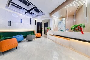 A modern hotel lobby with a reception desk, seating area, and a ceiling with geometric light fixtures. - BoYue Hotel (Yiwu International Trade City) (Yiwu)