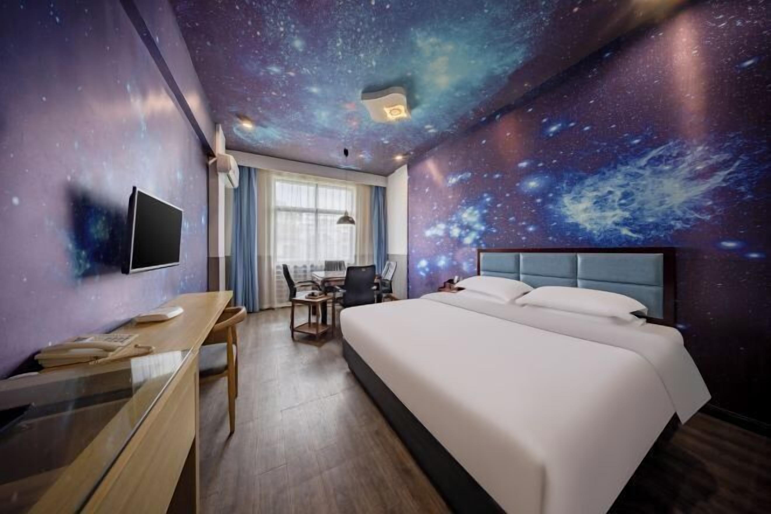 Une chambre d’hôtel équipée d’un lit, d’un bureau, d’une chaise et d’un téléviseur.