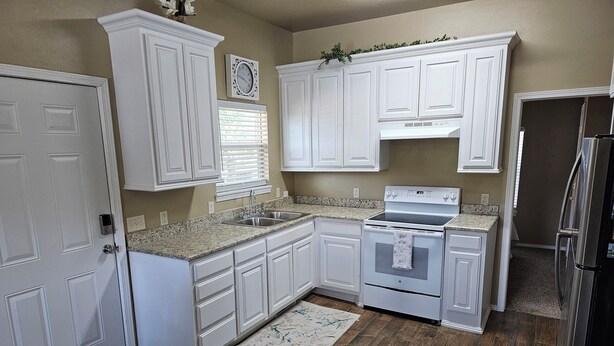 A kitchen with white cabinetry, a stainless steel refrigerator, a double oven, and a granite countertop. - Historic 3-bedroom house close to downtown Guthrie.  (Guthrie)