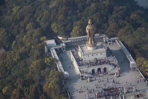 An aerial view of a large square with a prominent golden statue at the center, surrounded by a crowd of people. - Haitian Hotel (Zhoushan Shenjia Branch) (Zhoushan)