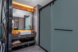 A modern bathroom with a marble vanity, a large mirror, and a sliding door. - Guangzhou Baisi Elegant Hotel (Huadu Shiling) (Guangzhou)
