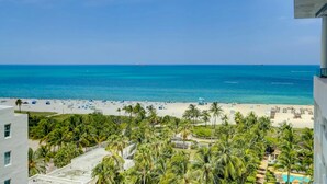 Blick auf einen Strand mit Palmen und blauem Himmel.