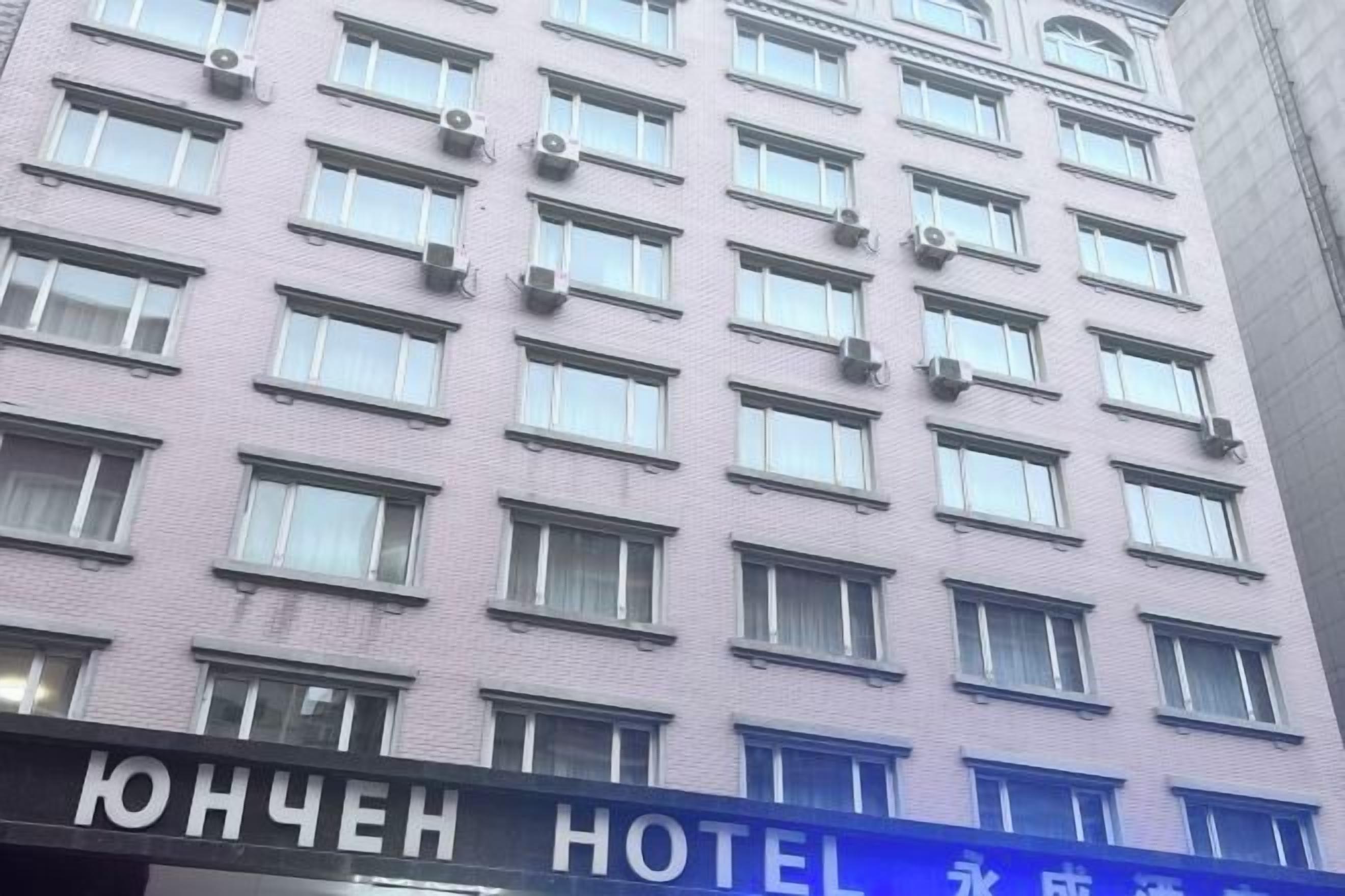 Un bâtiment d’hôtel doté de nombreuses fenêtres et d’une enseigne sur laquelle on peut lire « HÔTEL ».