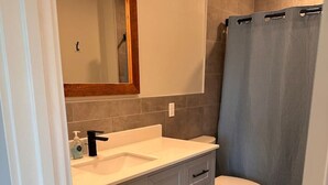 A bathroom with a white sink, a mirror, a toilet, and a shower curtain. - Terrace View Apartment (Moscow)