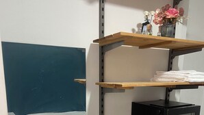 Une chambre d’hôtel de taille réduite, comprenant un lit, un lavabo, un miroir et un petit réfrigérateur.