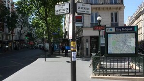 Une vue de rue avec un arrêt de bus, un panneau indiquant l’emplacement d’une station de métro et un panneau d’affichage avec une carte.