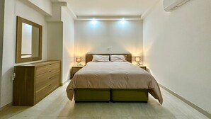 Une chambre à coucher avec un lit, des tables de chevet, une commode et un miroir.