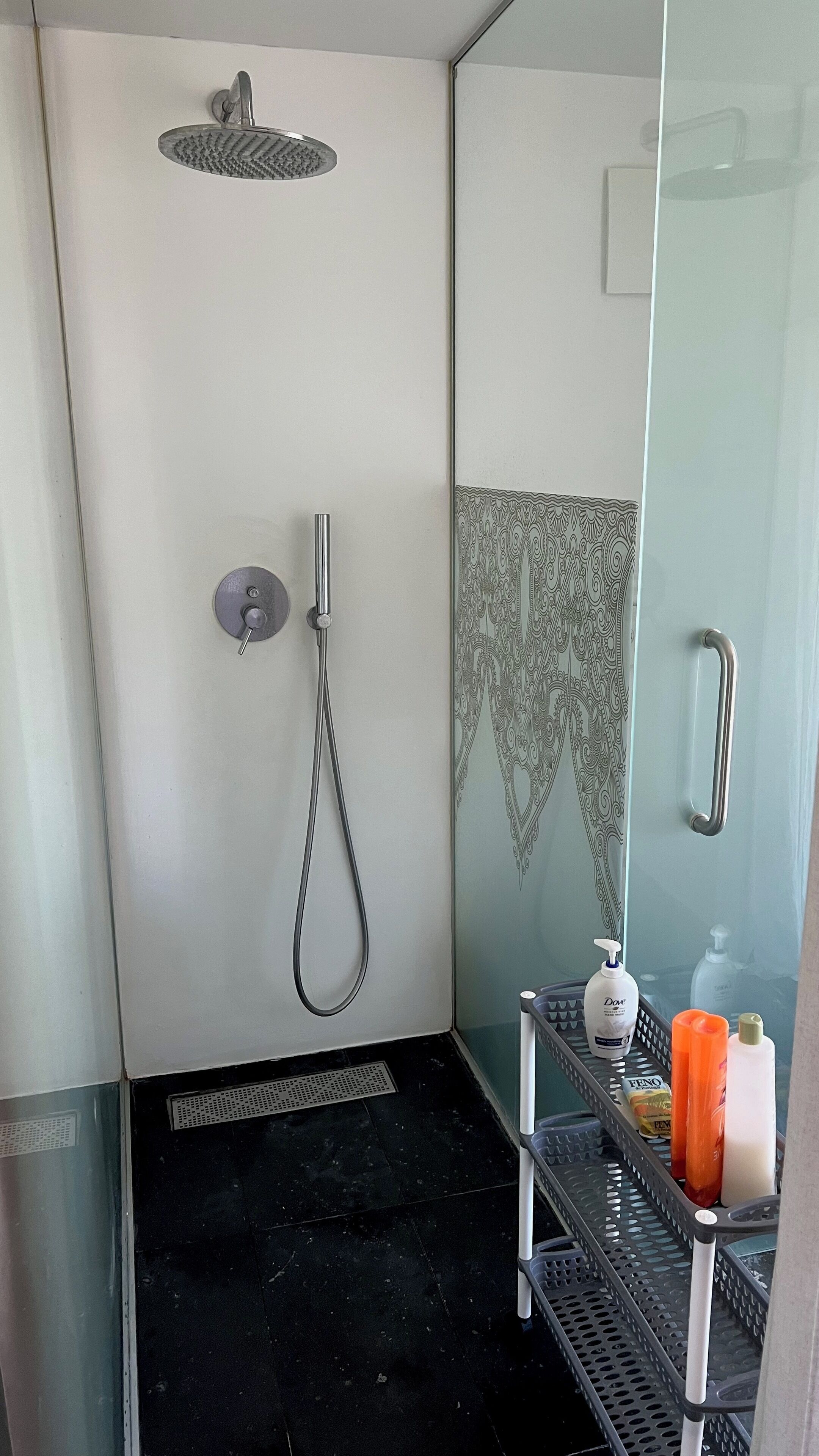 A modern shower with a handheld showerhead and a wall-mounted rain showerhead.