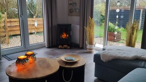 A cozy living room with a fireplace, a sofa, and a table with candles.