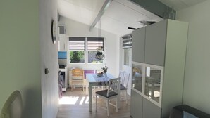 A modern living room with a sofa and a dining area with a table and chairs.