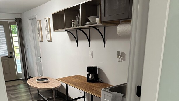 A compact kitchen with a wooden table, a coffee maker, and a built-in sink.