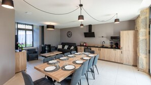 A modern kitchen with a dining area, built-in appliances, and a stone accent wall.