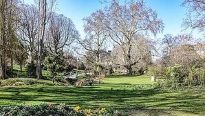 Un parc avec des arbres, une pelouse et un sentier.
