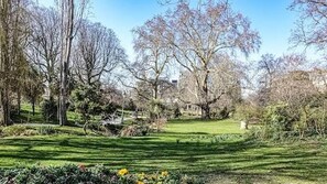 A park with trees, a lawn, and a pathway. - Au Pied de la Butte Montmartre Avec Toutes Sortes de Commerces à Moins de 5 Mins (Paris)