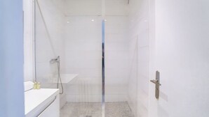 Une petite salle de bain moderne, équipée d’une douche, d’un lavabo et de toilettes.