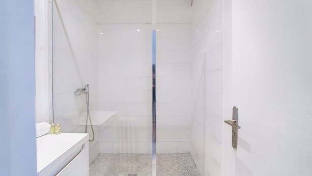 A small, modern bathroom with a shower, a sink, and a toilet. - Au Pied de la Butte Montmartre Avec Toutes Sortes de Commerces à Moins de 5 Mins (Paris)