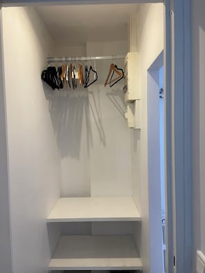 Un dressing avec espace pour suspendre les vêtements et des étagères.