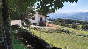 Une maison avec un mur en pierre et une vue sur la campagne.