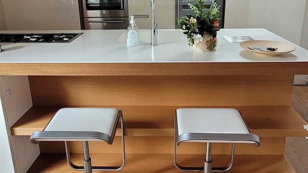 A modern kitchen with a central island, stainless steel appliances, and two bar stools. - Splendido Appartamento per il tuo Relax (Trentino-Alto Adige)