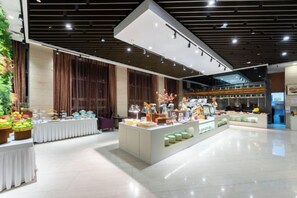A spacious hotel lobby with a central island display, large windows, and a modern ceiling design. - Nishi Hotel (Jinan)