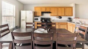 Une cuisine de taille réduite, dotée de meubles en bois, d’un four à micro-ondes, d’une cuisinière et d’un réfrigérateur.