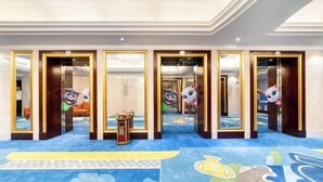 A hotel lobby with a blue carpet featuring animal patterns, a reception desk, and a fire extinguisher. - Shaoxing Shangyu Radisson Wanjin Hotel (Shaoxing)