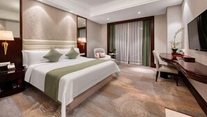 A hotel room with a large bed, a desk, and a chair. - Shaoxing Shangyu Radisson Wanjin Hotel (Shaoxing)