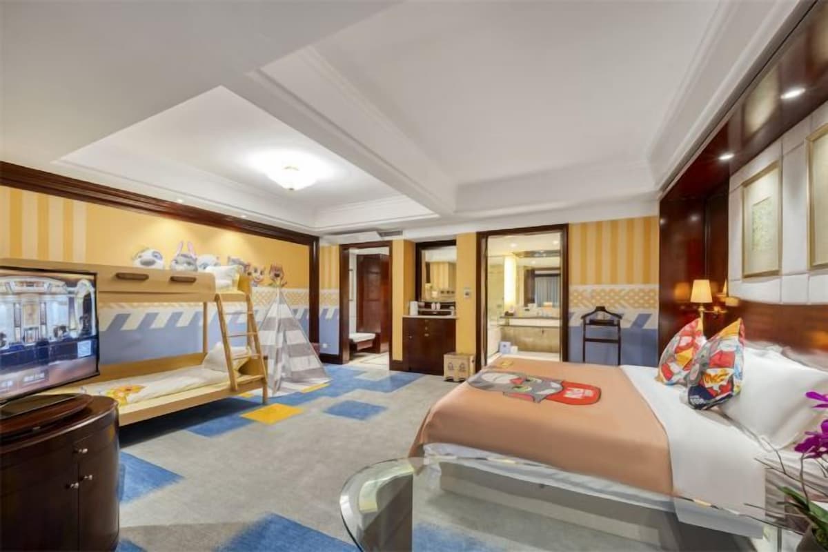 Habitación de hotel con cama, televisor, escritorio y baño.