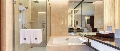 A modern bathroom with a glass-enclosed shower, a large mirror, and a marble sink.