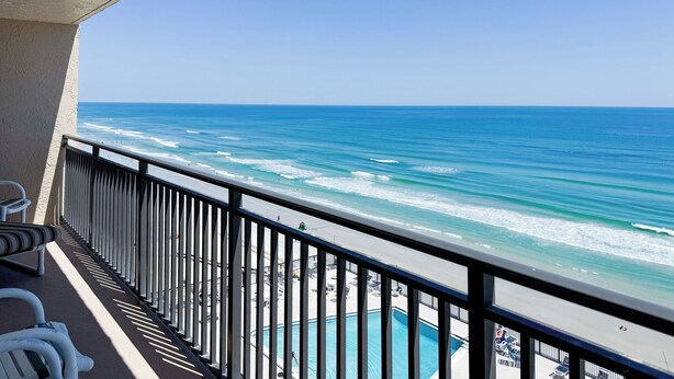 Un balcone con vista sull'oceano e su una zona piscina.