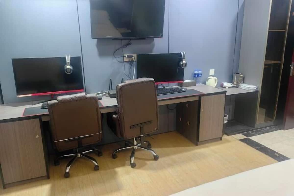 A modern office with two desks, two chairs, and two monitors.