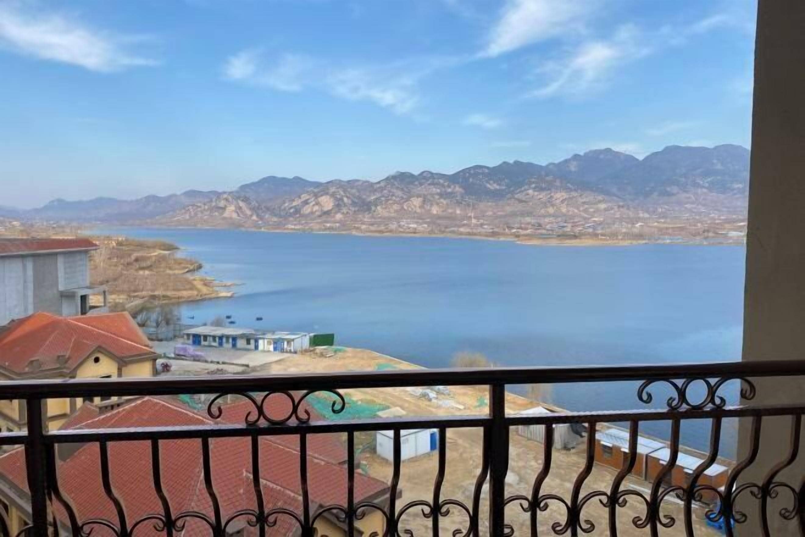 A balcony with a view of a lake and mountains.